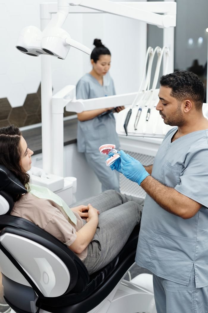 Dentist explains dental procedure to patient in a modern clinic setting.