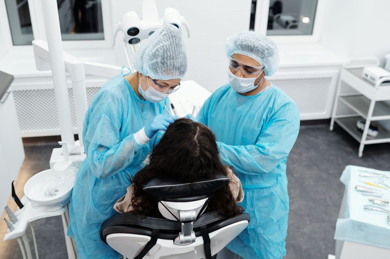 Dental professionals attend to a patient in a bright, modern clinic setting, emphasizing hygiene and care.