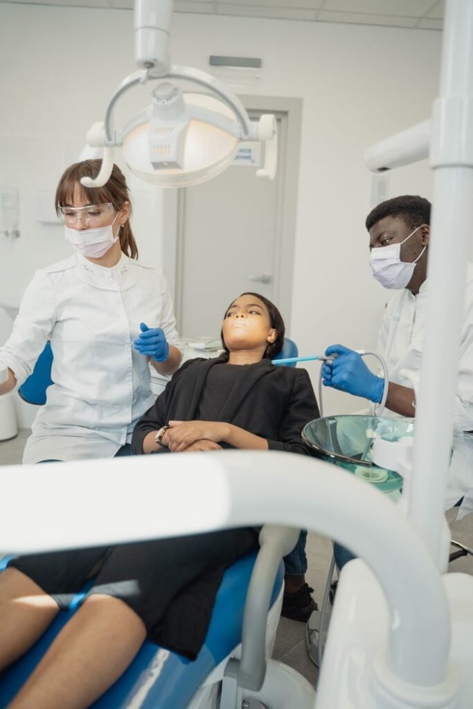 A dentist and assistant examine a patient in a modern dental clinic.