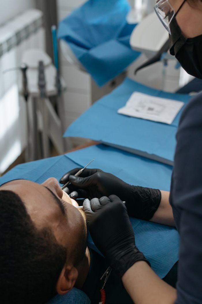 A dentist examines a patient during a routine dental checkup in a clinic.